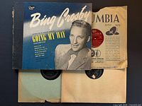 Bing Crosby Decca album cover over additional Columbia and plain-sleeved 78 rpm records