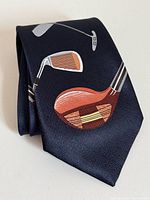 Front view of navy tie showing golf club graphics and woven texture