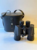 Binoculars standing with case behind