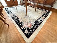 Full corner view showing beige field, black floral border under dining table