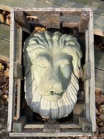 Top-down view of lion head sculpture in crate