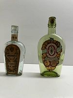 Front view of both vintage cognac bottles, showing labels and coloration