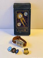 Group shot of all items: wrist counter, boxed Hoylake divot tool with markers, two loose ball markers, pin