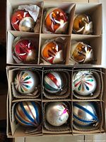 Box containing assorted round and tear-shaped glass ornaments in partitions