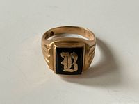 Front view of 10k gold signet ring showing black square face and gold B