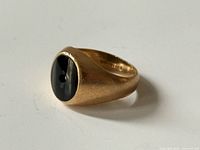 Ring profile showing gold shank and black stone with drilled hole