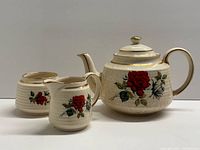 full view of teapot, sugar bowl, creamer showing pattern and size relation