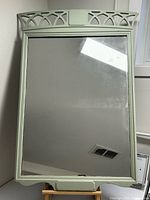 Front view of painted wood mirror showing frame, crest detail and glass