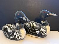 Two stuffed fabric loon pillows side by side