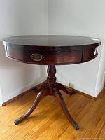 Full view of round wood parlour table with pedestal and splayed legs