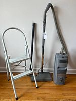 Overall view showing vacuum with hose, wand, powerhead and ladder