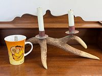 Antler candleholder with two taper candles and Dreamcatcher mug side by side