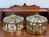 Both octagonal brass and glass ceiling fixtures with bulbs installed