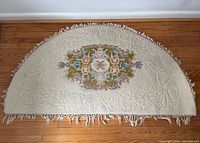 Full view of half-moon wool rug on wood floor