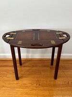 Full view of mahogany butler’s tray table with oval tray top and four legs