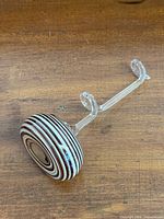 Side view showing striped disc base and clear looping stem