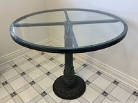 oblique view of table showing glass top and pedestal base