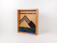 Front view of framed wood mosaic showing geometric mountain and lake design