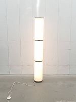 Full view of Ikea Vidja floor lamp lit, showing height and cord