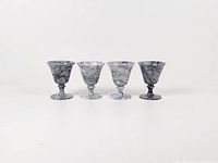 Front view of four polished grey marble goblets