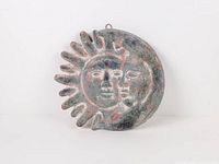 Front view of sun and moon pottery plaque showing full design