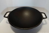 Top view of cast iron wok showing interior surface and handles