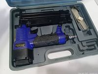 Brad nailer in carry case with fastener strips visible