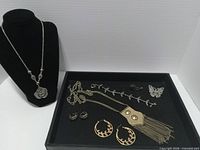 All items displayed together on bust and tray