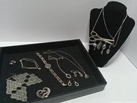 Full lot overview showing necklaces on bust and jewelry in tray