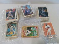Five stacks of baseball cards wrapped in plastic, assorted fronts visible