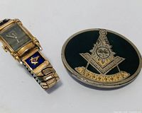 Front view of gold-tone wristwatch and green enamel Masonic belt buckle