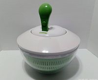 Salad spinner assembled showing spinning lid and handle