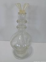 Front view of clear four-chamber decanter showing spouts inserted