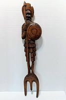 Front view of carved wood Viking with spear, shield and forked base