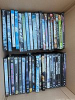 Two rows of DVD spines visible inside open cardboard box