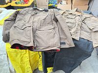 All three jackets displayed: brown canvas, black oilskin, tan twill