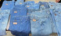 Front view of all jeans laid out showing variety of washes and leather patches