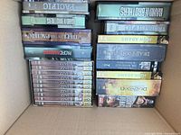 Box with multi-disc TV/documentary DVD sets (Band of Brothers, The Pacific, Ken Burns Jazz, Deadwood, John Adams)