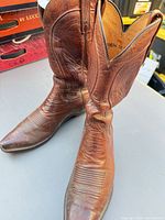 Side view of both boots showing leather color, toe shape and wear