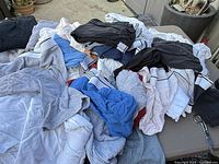 Pile of assorted men’s T-shirts and underwear on table
