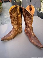 Pair of brown distressed leather cowboy boots angled view