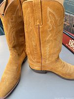 side view of both boots showing suede finish, stitching, heel