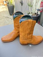 Side view of both boots showing ostrich leather texture and shafts