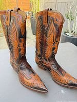 Front/side view of both boots showing two-tone leather, stitching, toe shape, and shaft height