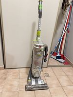 Full view of Hoover Air upright vacuum standing on tile floor