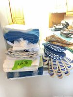 Overall lot showing stacked towels, cloths, potholders and gloves