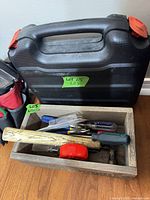 Closed carry case beside wood crate with hand tools