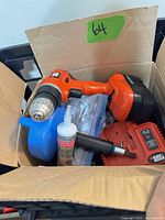 Box showing Black & Decker drill, battery attached, adhesive tube, blue funnel, auxiliary handle and accessories
