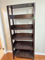 Full front view of tall dark brown 6-shelf cabinet with wine glass rack