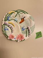front of ceramic plate showing swan and flowers